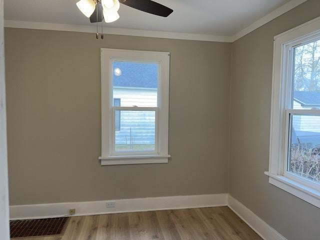 unfurnished room featuring light wood-type flooring, ceiling fan, and crown molding