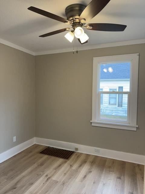 spare room with hardwood / wood-style flooring, ceiling fan, and crown molding