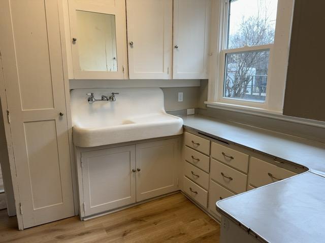 kitchen with light hardwood / wood-style floors and white cabinetry