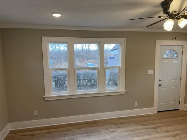 entrance foyer with ceiling fan, light hardwood / wood-style flooring, and ornamental molding