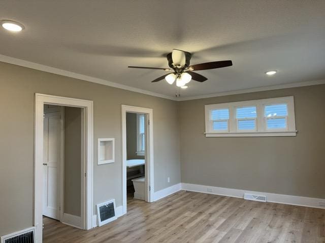 unfurnished bedroom with light wood-type flooring, ensuite bathroom, ceiling fan, and crown molding