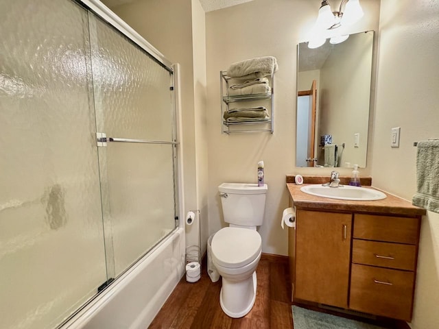 full bathroom with toilet, vanity, combined bath / shower with glass door, and hardwood / wood-style flooring