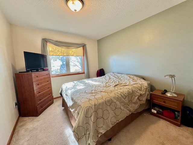 bedroom featuring light carpet and a textured ceiling