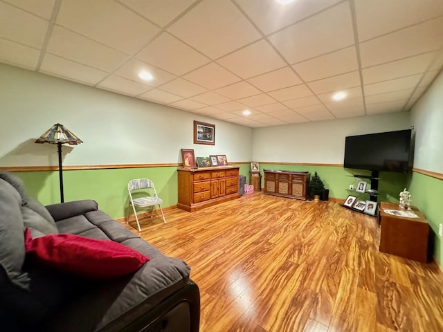 living room featuring hardwood / wood-style floors and a drop ceiling