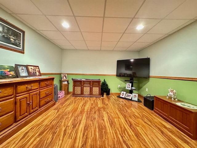 interior space featuring a paneled ceiling and light hardwood / wood-style flooring