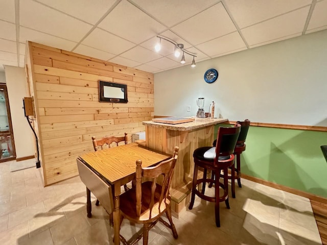 bar with a drop ceiling and wooden walls