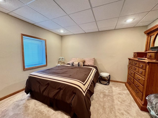 carpeted bedroom featuring a drop ceiling