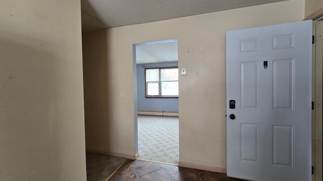 entryway with tile patterned flooring, a textured ceiling, and a baseboard radiator