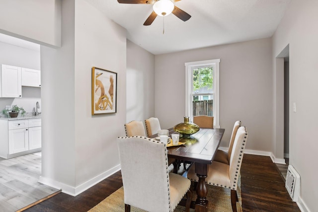 dining space featuring ceiling fan, sink, and wood-type flooring