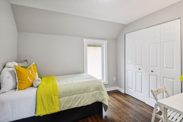 bedroom featuring dark hardwood / wood-style flooring, vaulted ceiling, and a closet