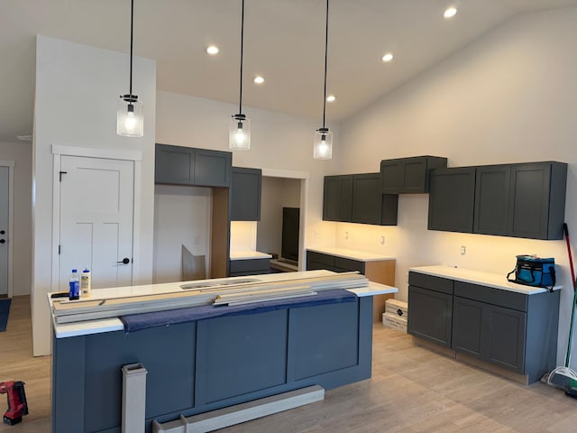 kitchen with a center island, light hardwood / wood-style floors, high vaulted ceiling, and hanging light fixtures