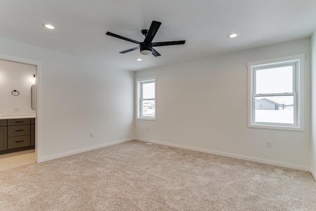 spare room featuring a ceiling fan, recessed lighting, light carpet, and baseboards