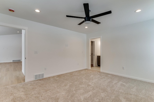 spare room with light colored carpet, recessed lighting, and visible vents