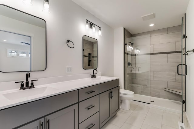 bathroom with toilet, a stall shower, double vanity, and a sink