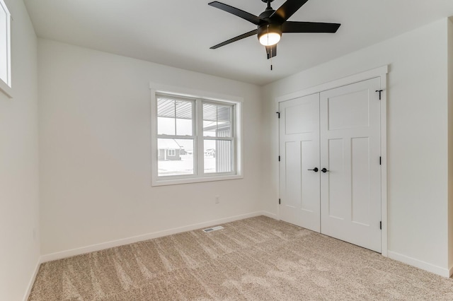 unfurnished bedroom with carpet floors, a closet, visible vents, and baseboards