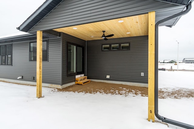 snow covered patio with entry steps and a ceiling fan