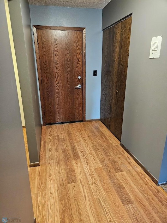 corridor with light hardwood / wood-style flooring