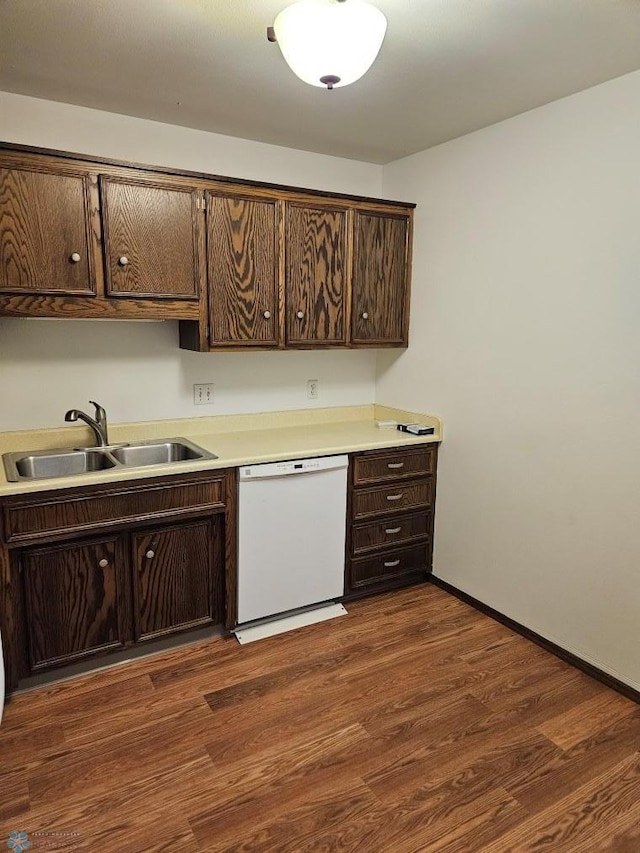 kitchen with dark brown cabinetry, sink, white dishwasher, and dark hardwood / wood-style flooring