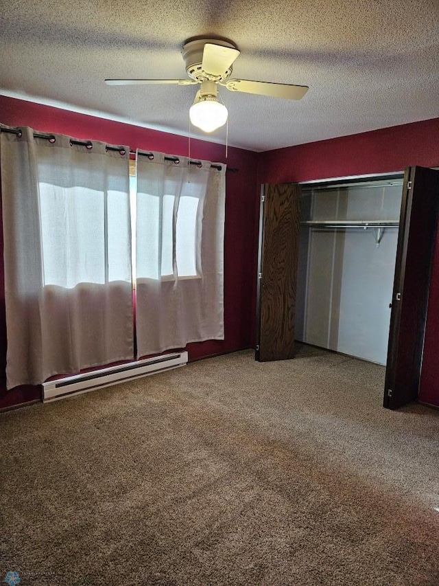 unfurnished bedroom featuring carpet flooring, ceiling fan, baseboard heating, a textured ceiling, and a closet