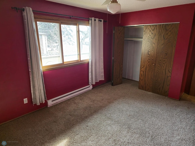 unfurnished bedroom with carpet, a ceiling fan, a closet, a textured ceiling, and a baseboard heating unit