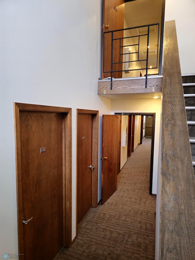 corridor with carpet and a towering ceiling