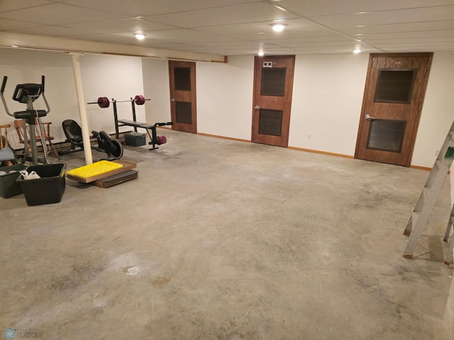 finished basement with a paneled ceiling and baseboards