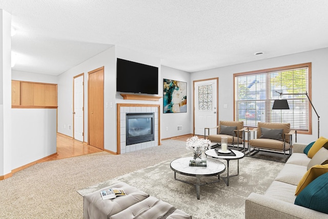 carpeted living room featuring a textured ceiling and a tiled fireplace