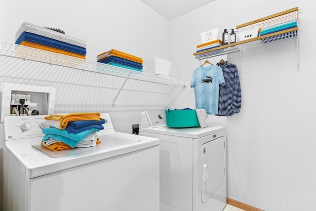 clothes washing area featuring washing machine and dryer and a textured ceiling