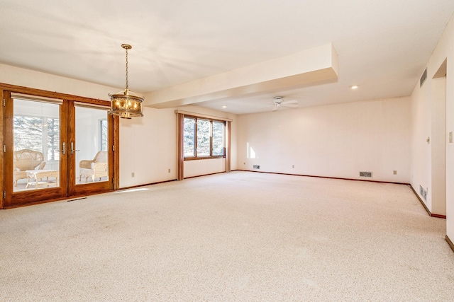 carpeted spare room with ceiling fan and french doors