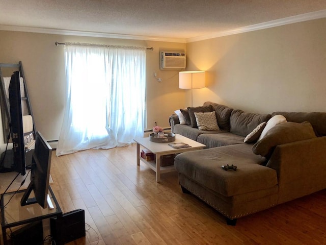 living room featuring an AC wall unit, crown molding, and hardwood / wood-style floors