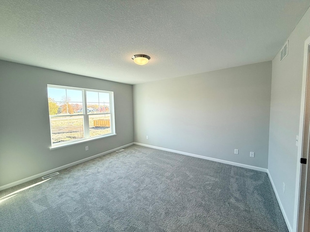 carpeted spare room featuring a textured ceiling