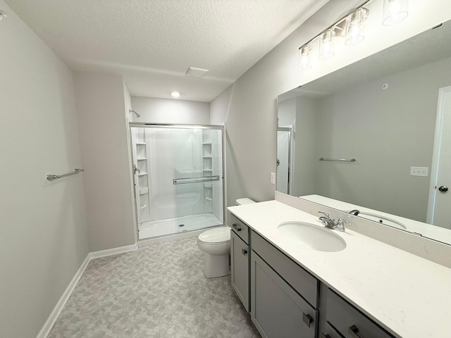 bathroom with a shower with door, vanity, a textured ceiling, and toilet