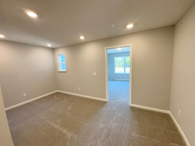 spare room featuring dark colored carpet