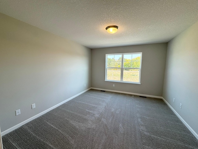 unfurnished room with dark carpet and a textured ceiling