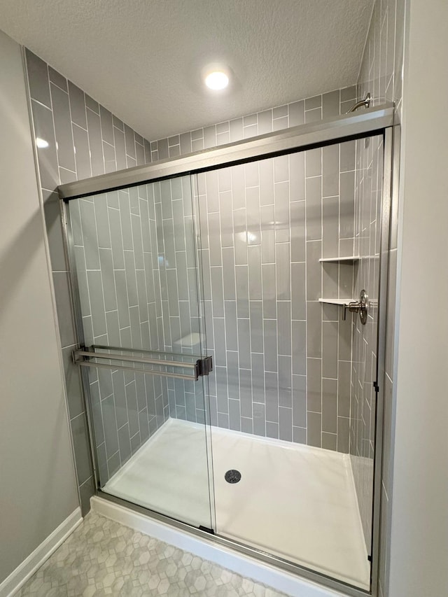 bathroom with a textured ceiling and walk in shower