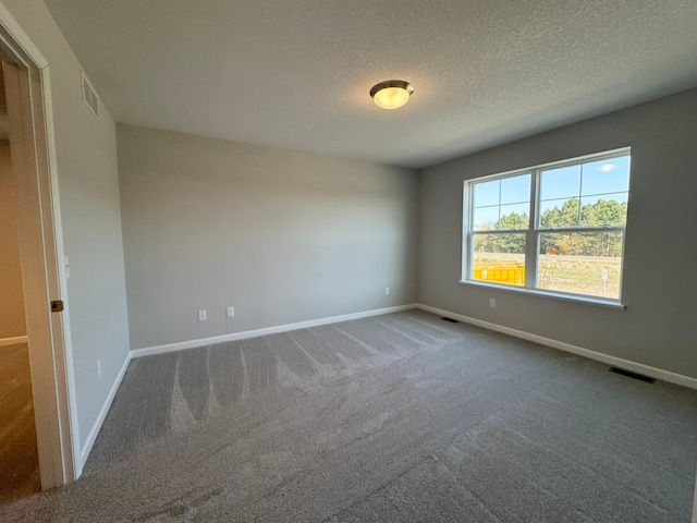 carpeted empty room with a textured ceiling