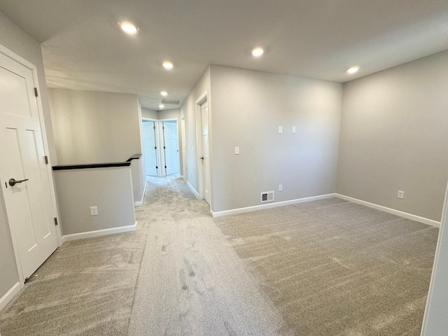 unfurnished room featuring light carpet