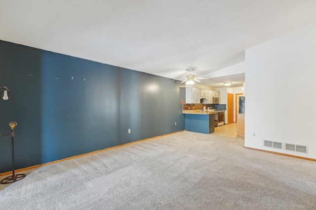 unfurnished living room featuring lofted ceiling, light carpet, and ceiling fan