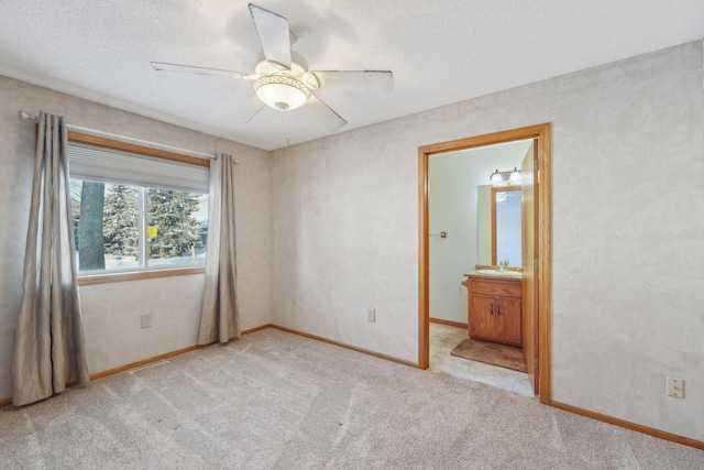 carpeted spare room featuring sink, a textured ceiling, and ceiling fan