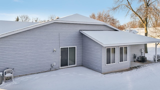 snow covered house with central AC unit