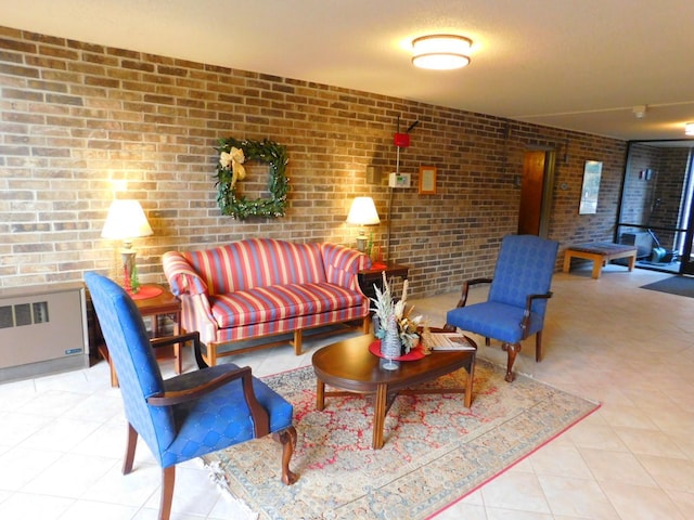 living room with radiator, light tile patterned floors, and brick wall