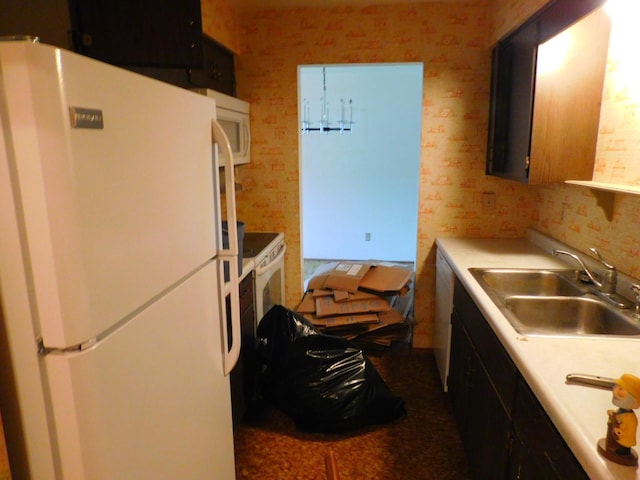 kitchen featuring white appliances and sink