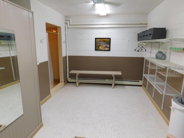 misc room featuring light tile patterned floors, a textured ceiling, and a baseboard heating unit