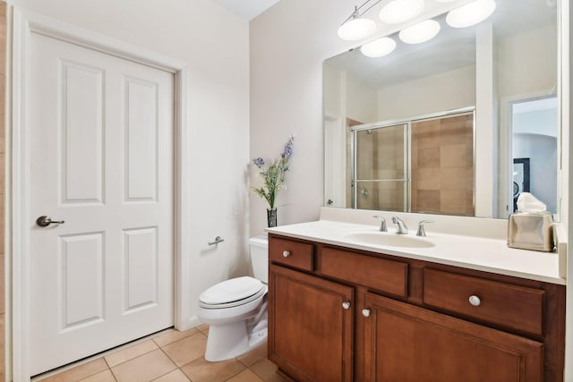 bathroom with toilet, vanity, tile patterned floors, and walk in shower