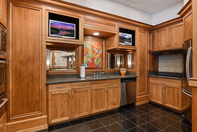 kitchen with sink, appliances with stainless steel finishes, and dark stone counters