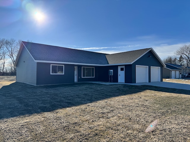 ranch-style house with a garage and a front lawn