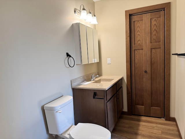 bathroom featuring hardwood / wood-style floors, vanity, and toilet