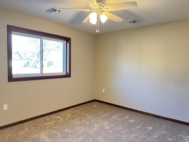 unfurnished room with ceiling fan and carpet