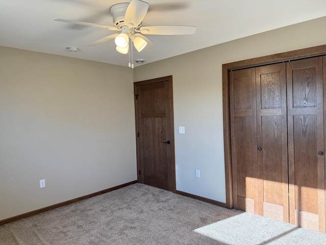 unfurnished bedroom with light colored carpet, ceiling fan, and a closet