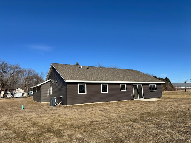 rear view of house with a yard and central AC